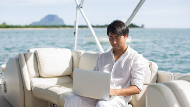 Businessman working with computer on a boat, nice outdoor office